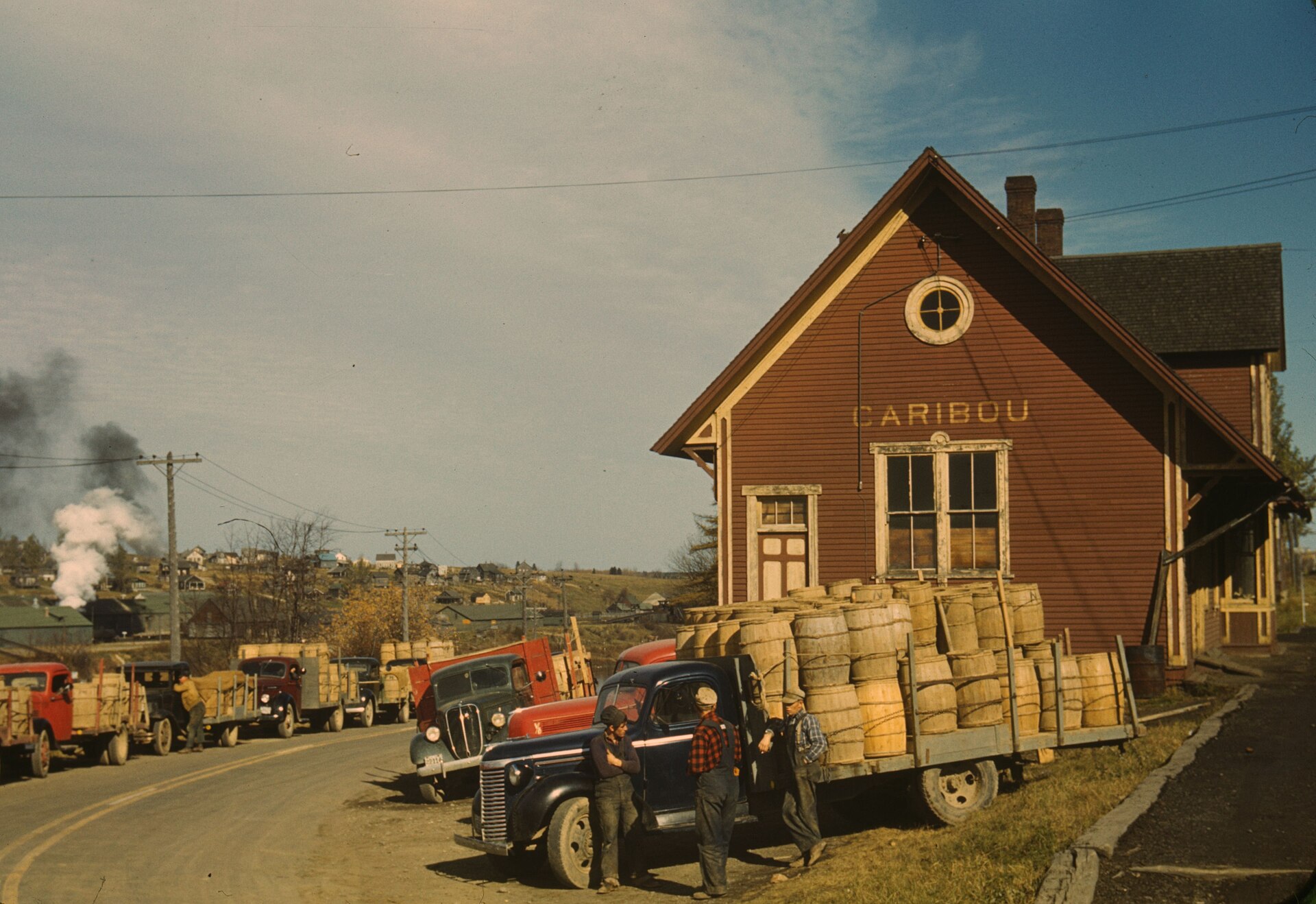 Farmers loading potato barrels onto trucks at the Caribou freight station, Aroostook County, Maine, October 1940