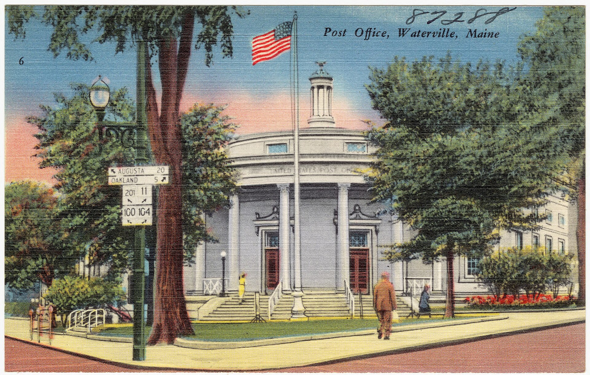 The Waterville post office on a linen postcard from the 1930s or 40s, with its columns, a flag and the elm out front